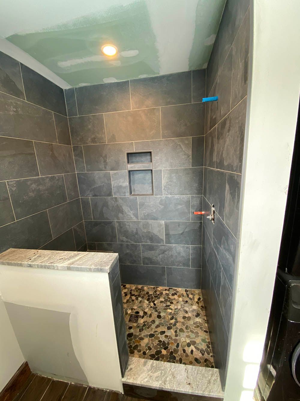 A bathroom with a walk in shower and tiled walls.