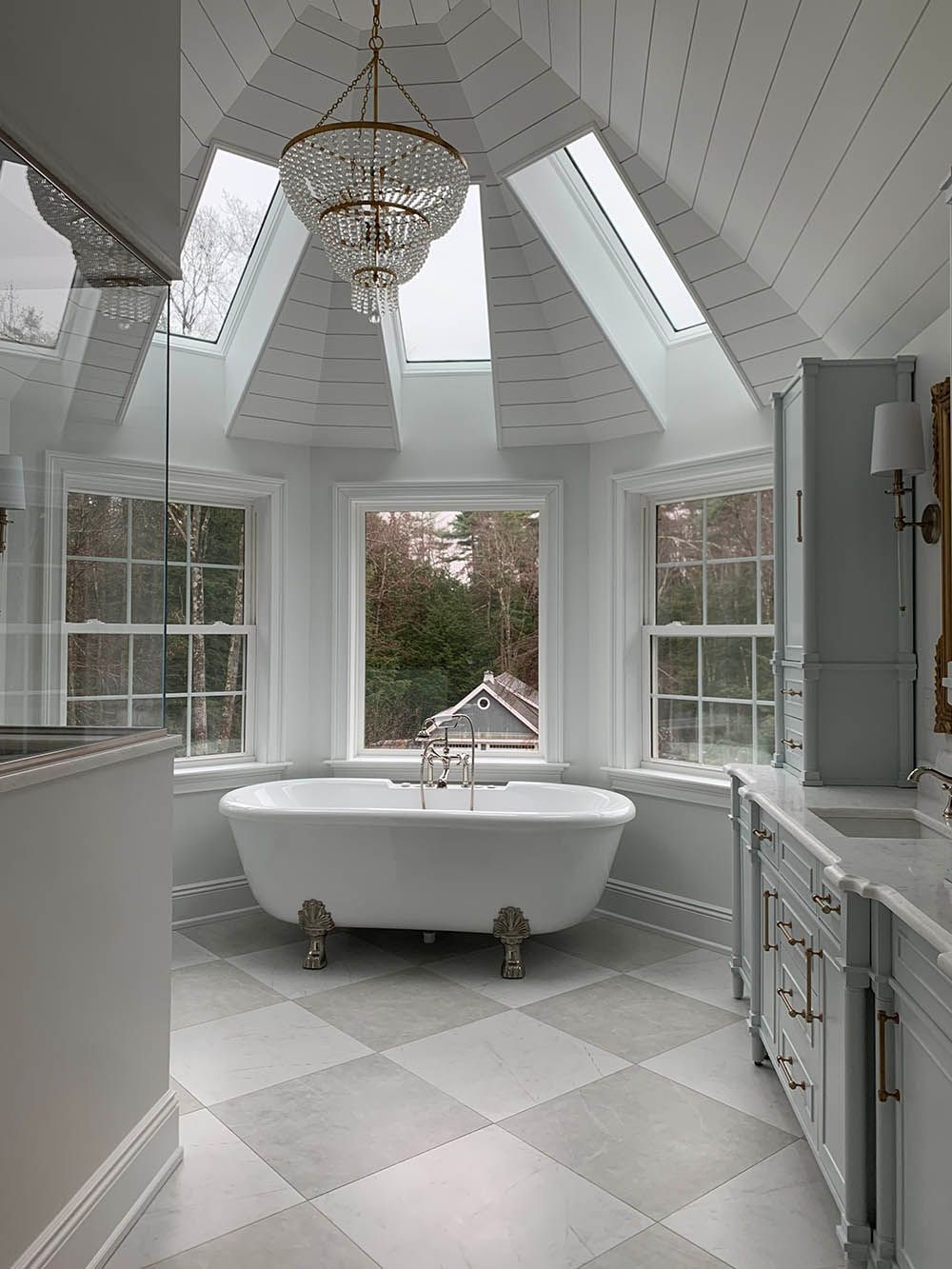 A bathroom with a claw foot tub and a skylight.