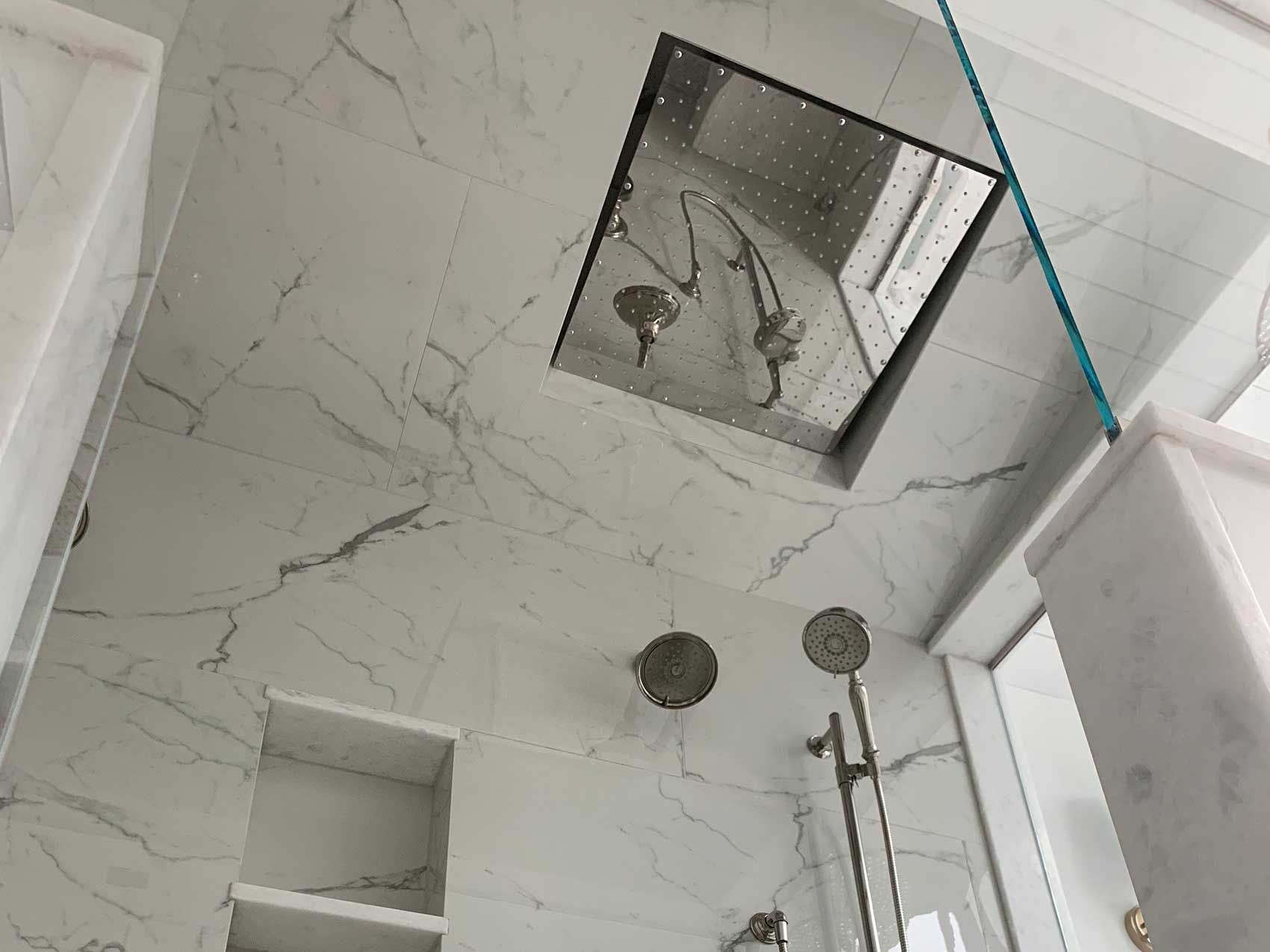 A bathroom with a shower and a mirror on the ceiling.