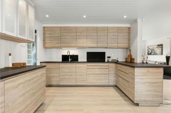 A kitchen with wooden cabinets and black counter tops.