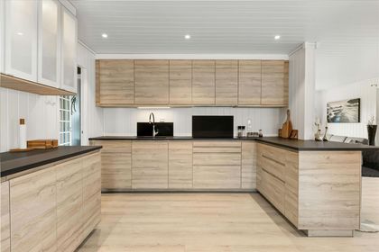 A kitchen with wooden cabinets and black counter tops.