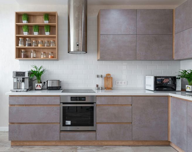A kitchen with stainless steel appliances and gray cabinets.