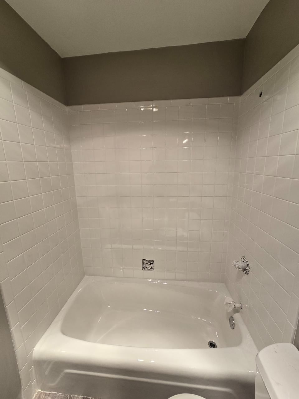 A bathtub is being painted white in a bathroom.