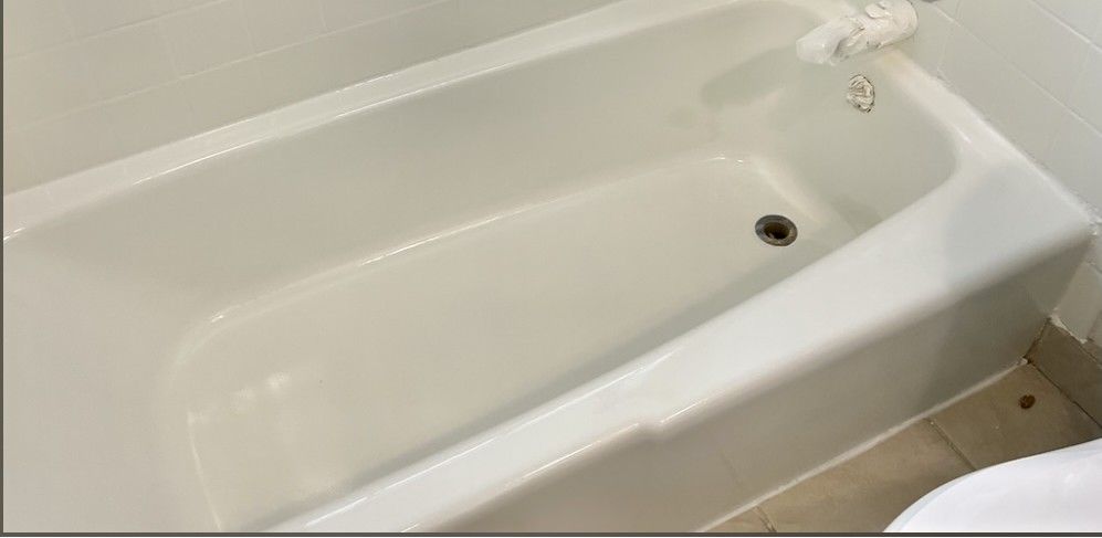 A white bathtub in a bathroom next to a toilet.