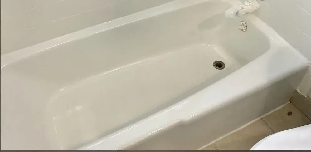A white bathtub in a bathroom next to a toilet.
