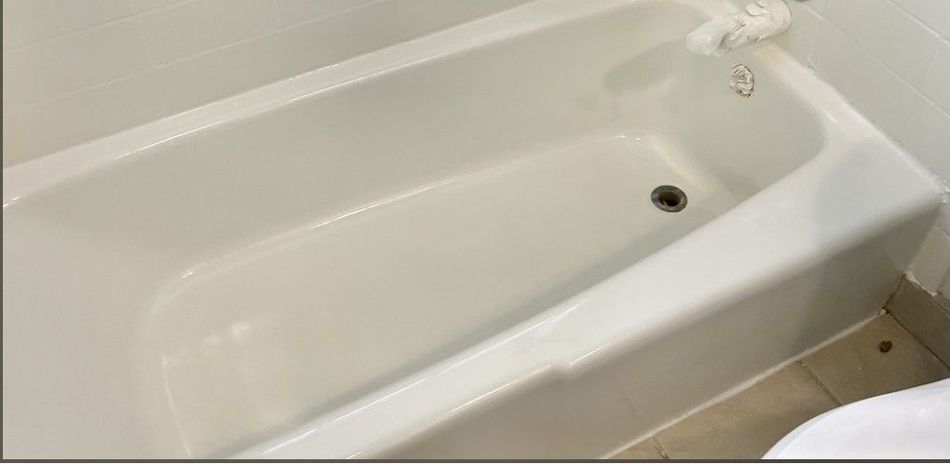 A white bathtub in a bathroom next to a toilet.