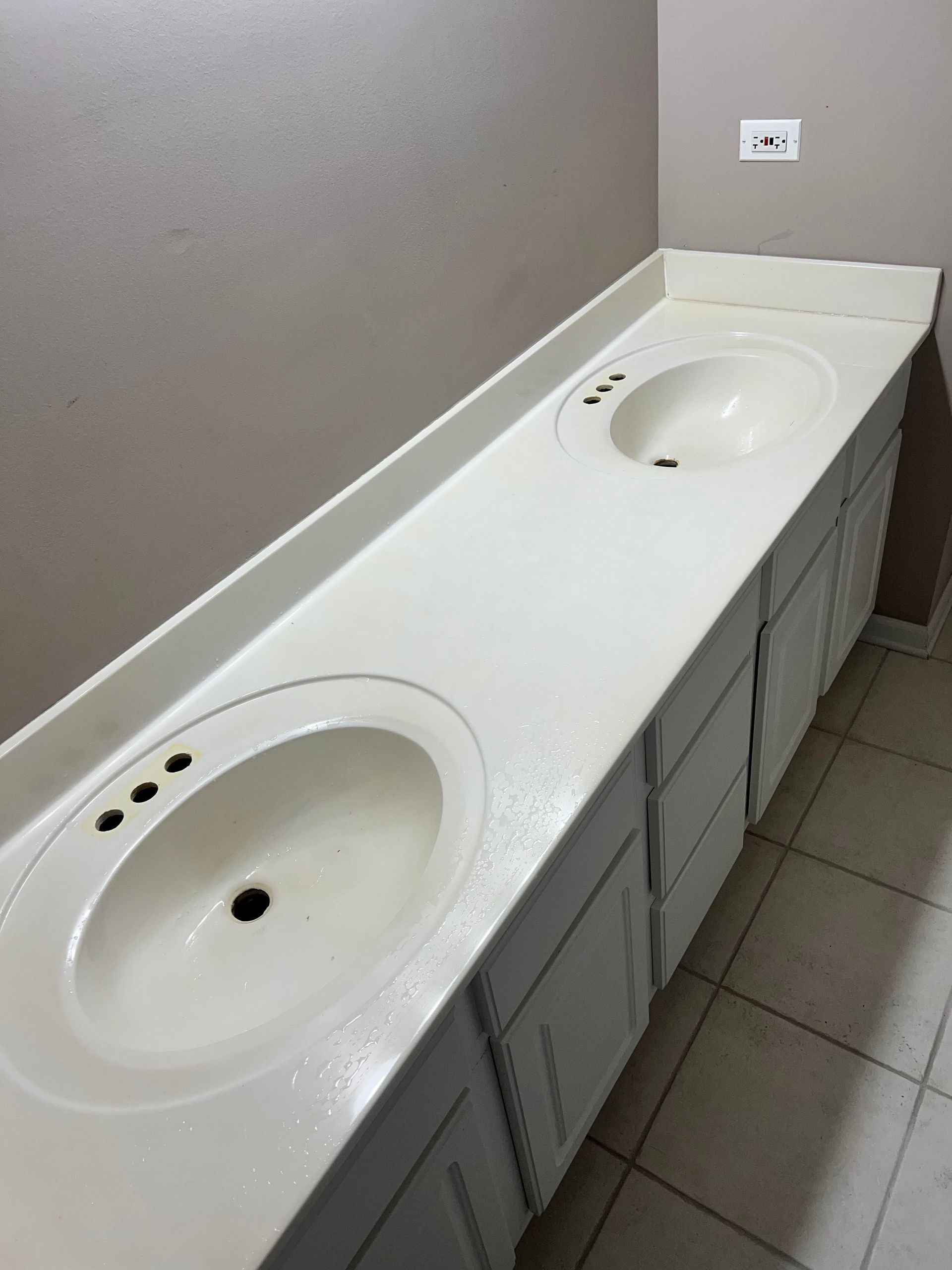 A bathroom with two sinks , two mirrors and a wine rack.