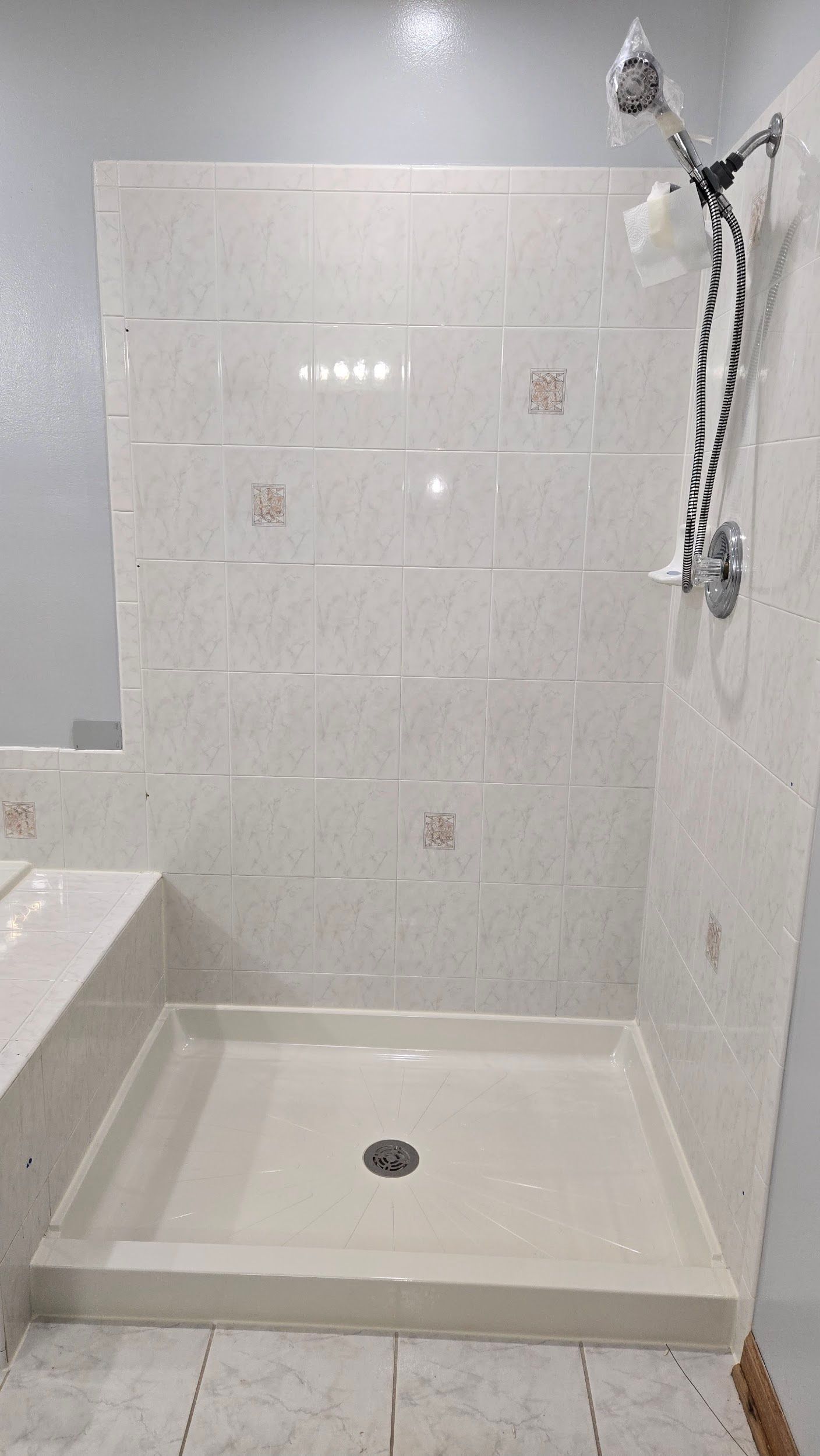 A bathroom with a shower stall and a shower head.