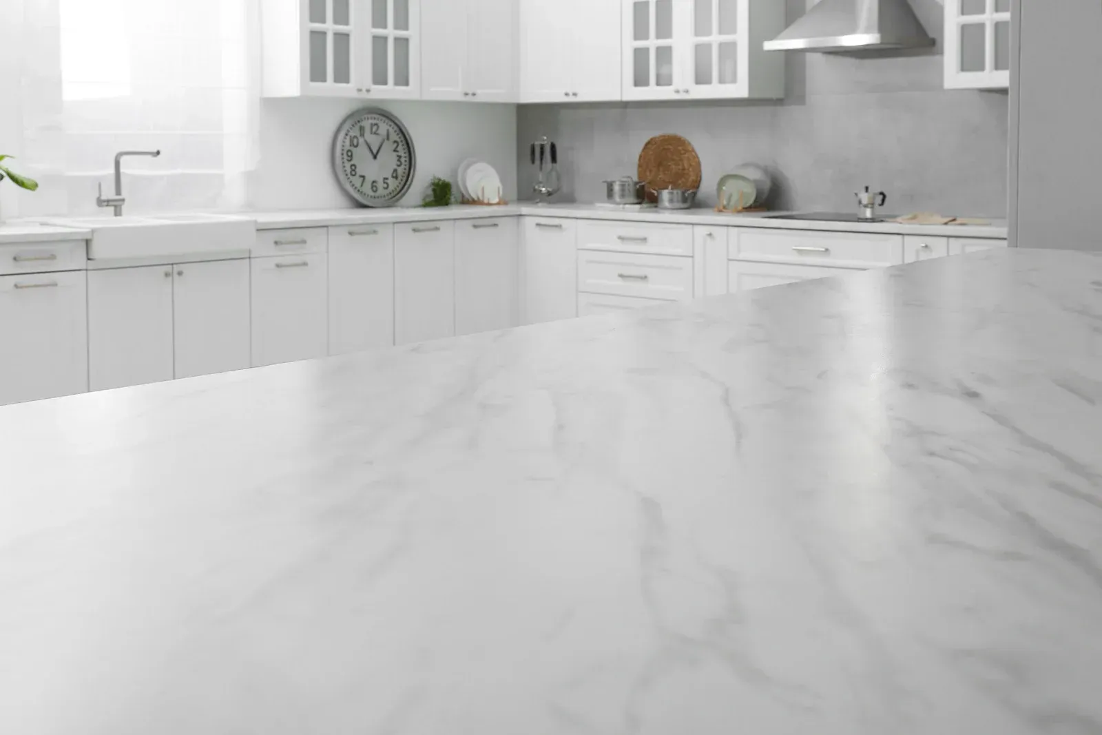 A kitchen with white cabinets and a marble counter top.