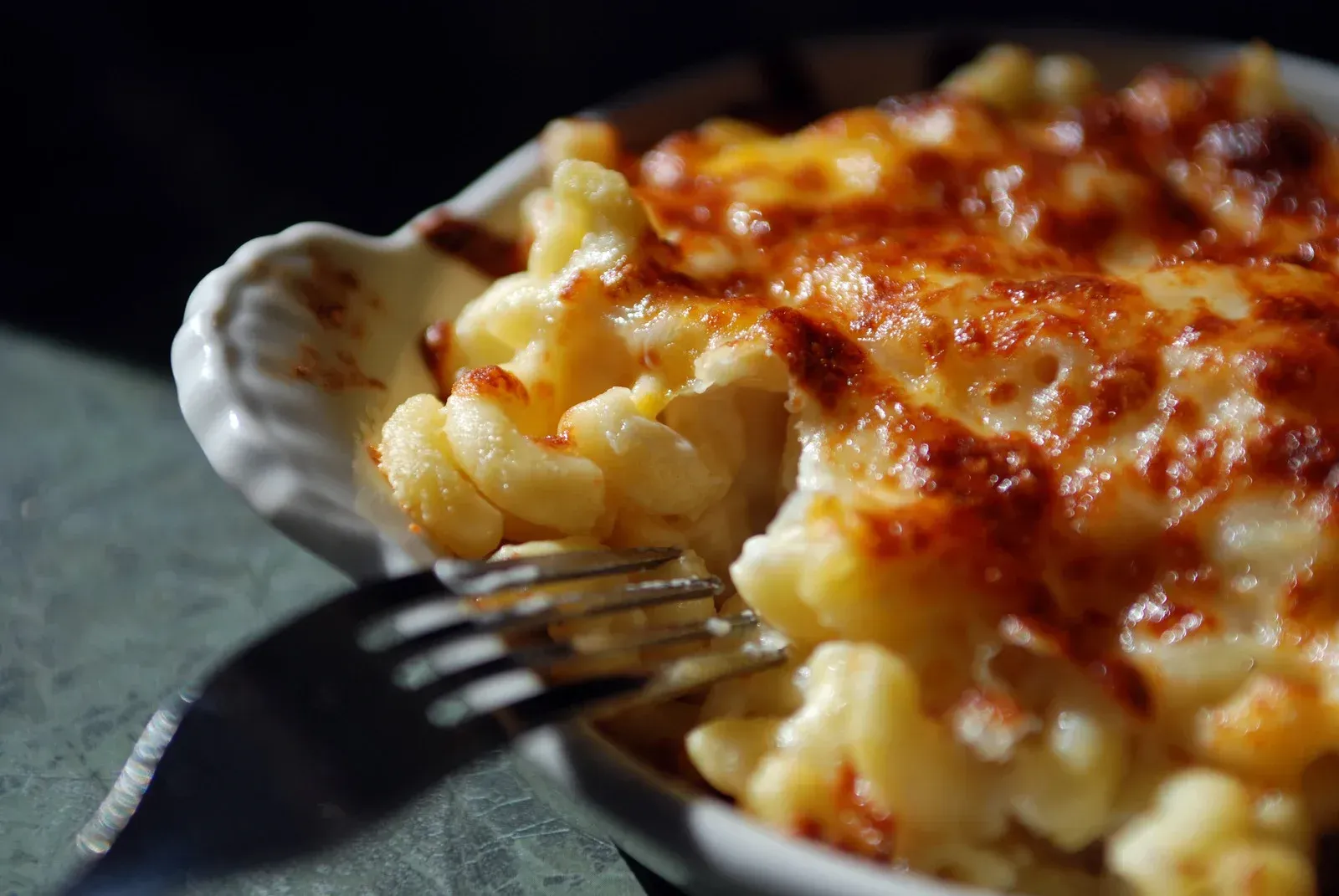 A bowl of macaroni and cheese with a fork in it