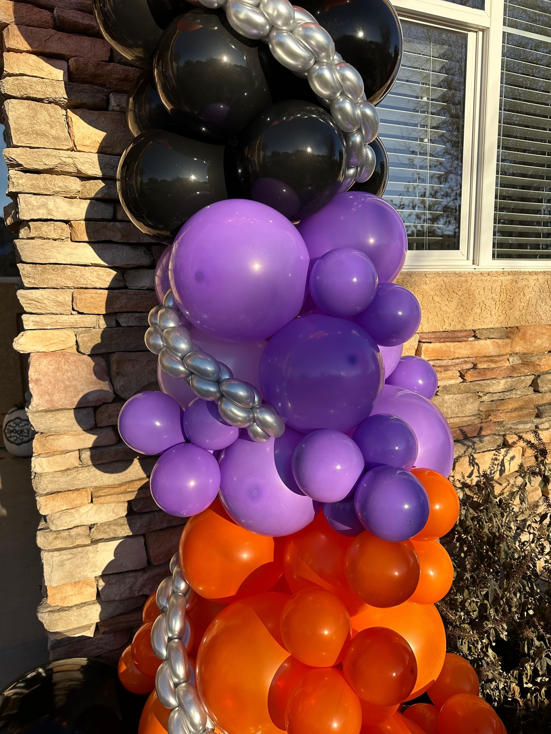 Balloon column, black, purple, and orange balloons, decorated for a holiday.