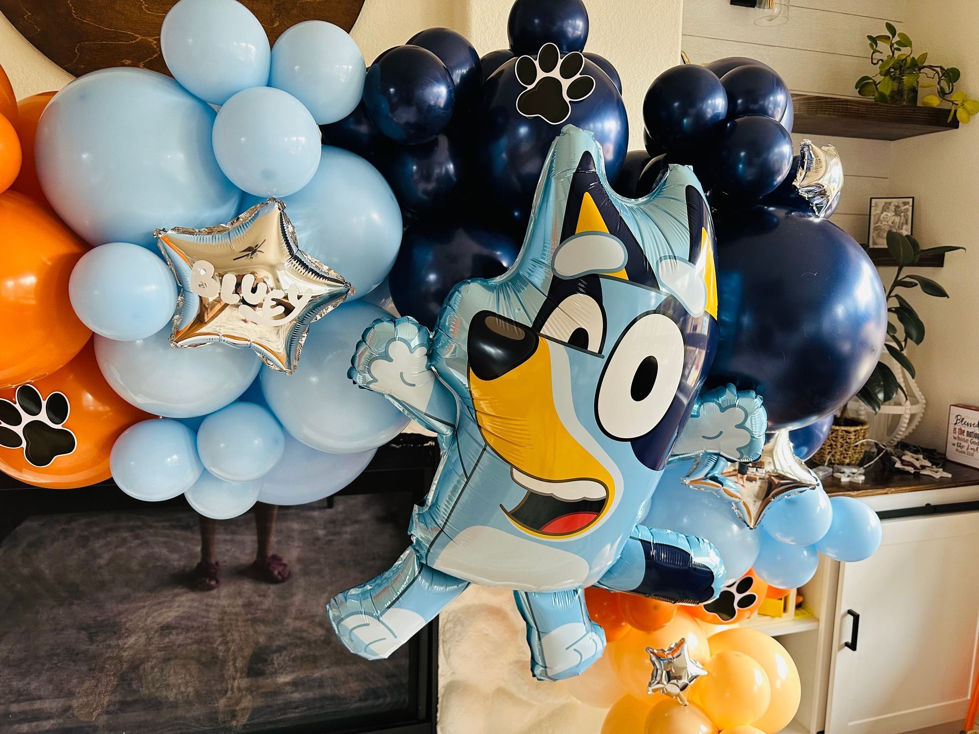Bluey balloon bouquet with blue and orange balloons and paw print accents.