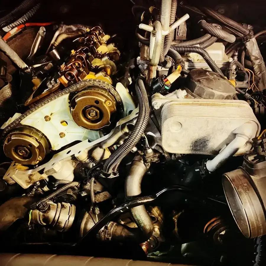 Engine components under repair, including timing chain and oil cooler.