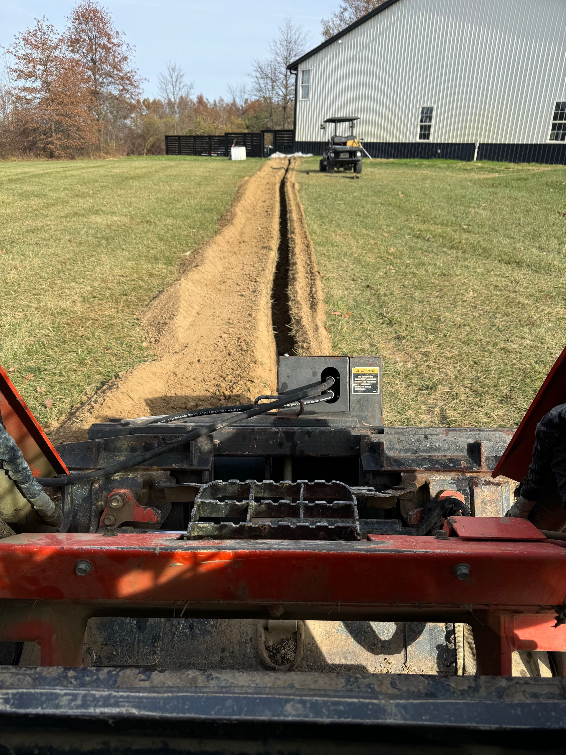 A tractor is digging a trench in a field.