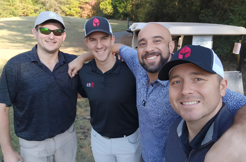 A group of men are posing for a picture on a golf course.
