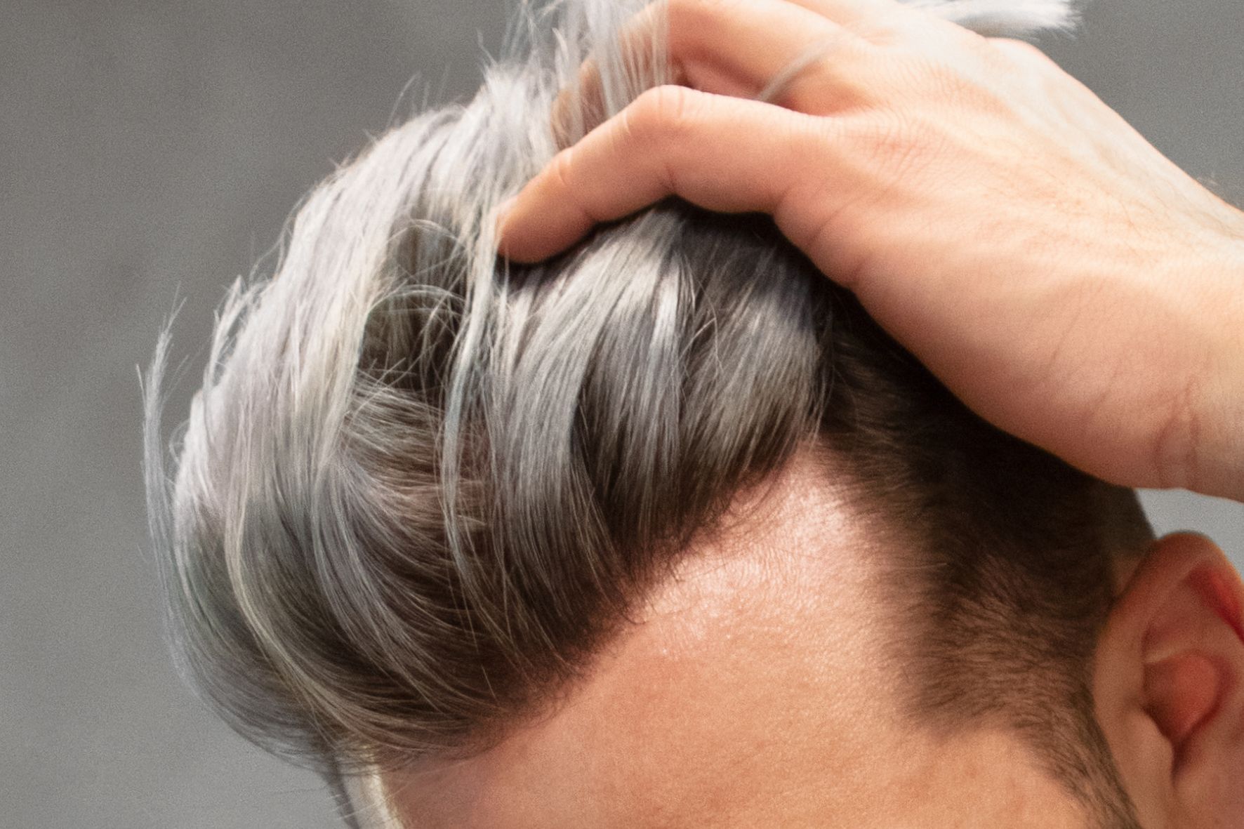 Doctor examines a man's face with a medical instrument; both are wearing gloves, mask and lab coat.