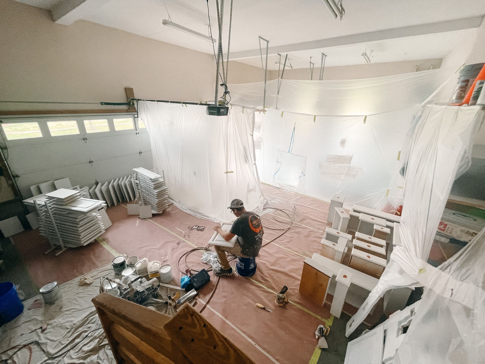 A man is painting a wall in a garage.