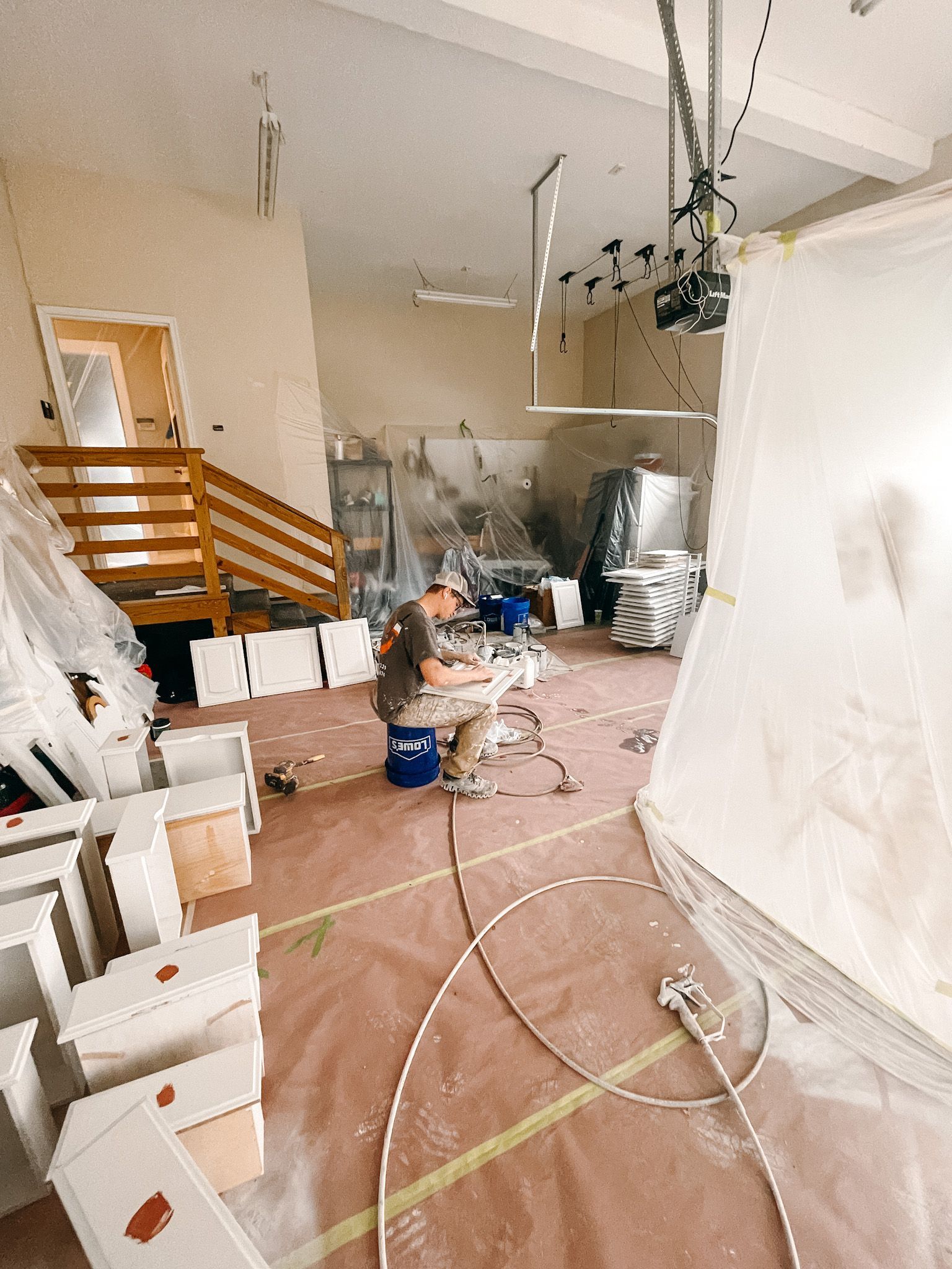 A man is sitting at a table in a room with a lot of boxes on the floor.