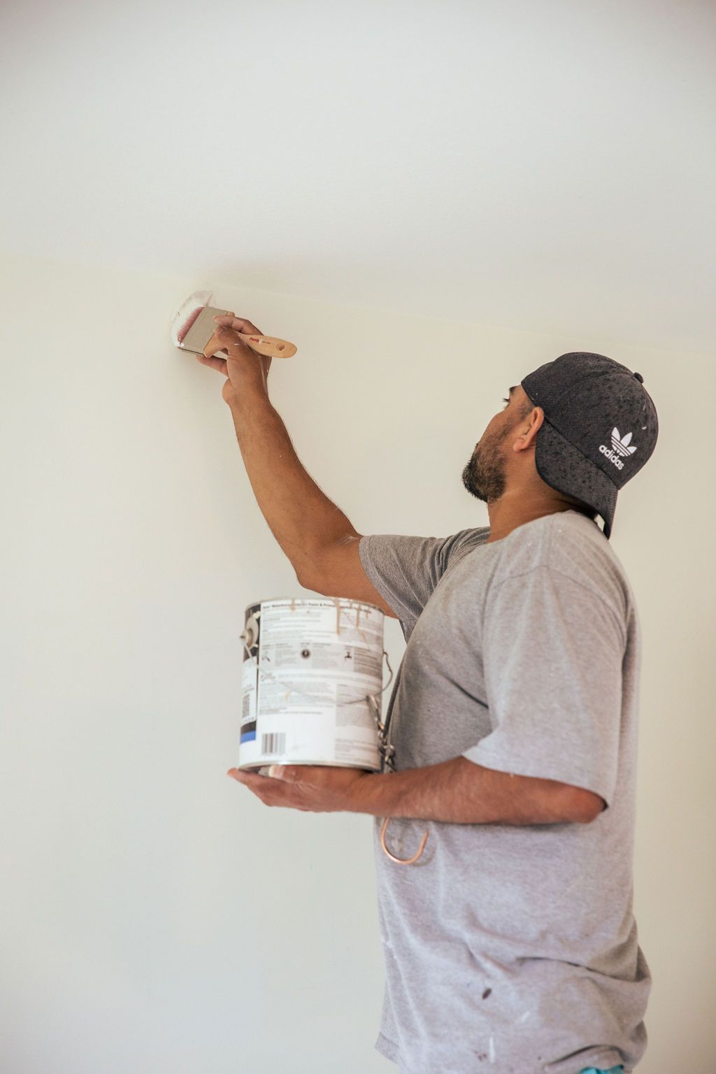 A man is painting a wall with a brush.