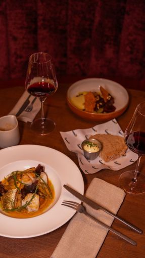 Een hotelkamer met twee bedden en een schilderij aan de muur.