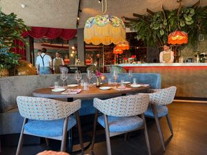 Een hotelkamer met een groot bed, stoelen en een schilderij aan de muur.