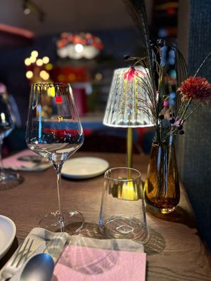 Een hotelkamer met een groot bed, stoelen en een schilderij aan de muur.