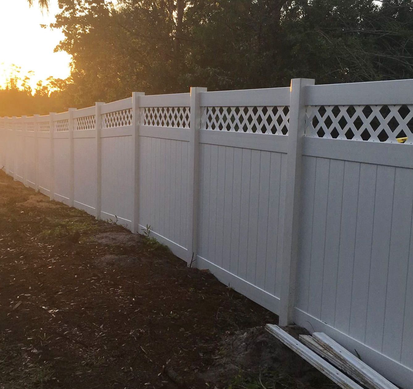 A white fence with a lattice design on it