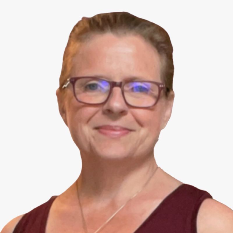 A woman wearing glasses and a red tank top smiles for the camera
