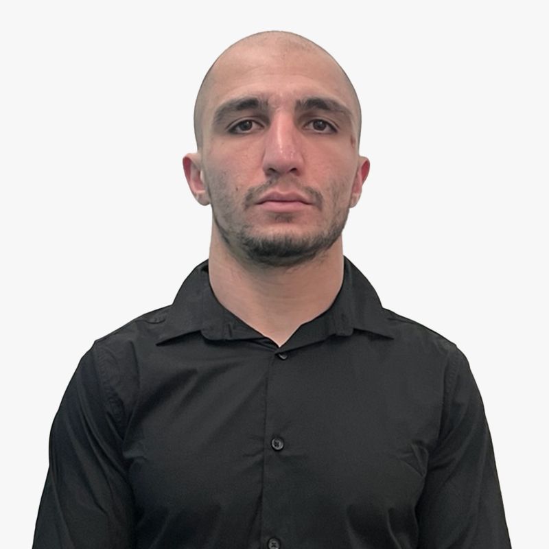 A bald man with a beard is wearing a black shirt