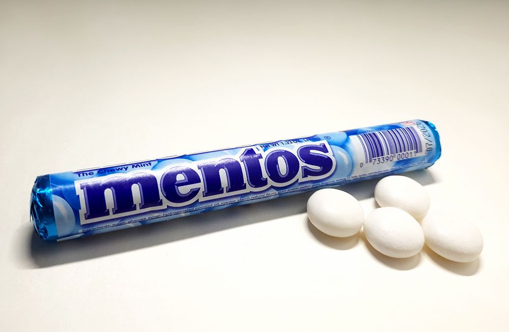 A roll of mentos mints next to some mints