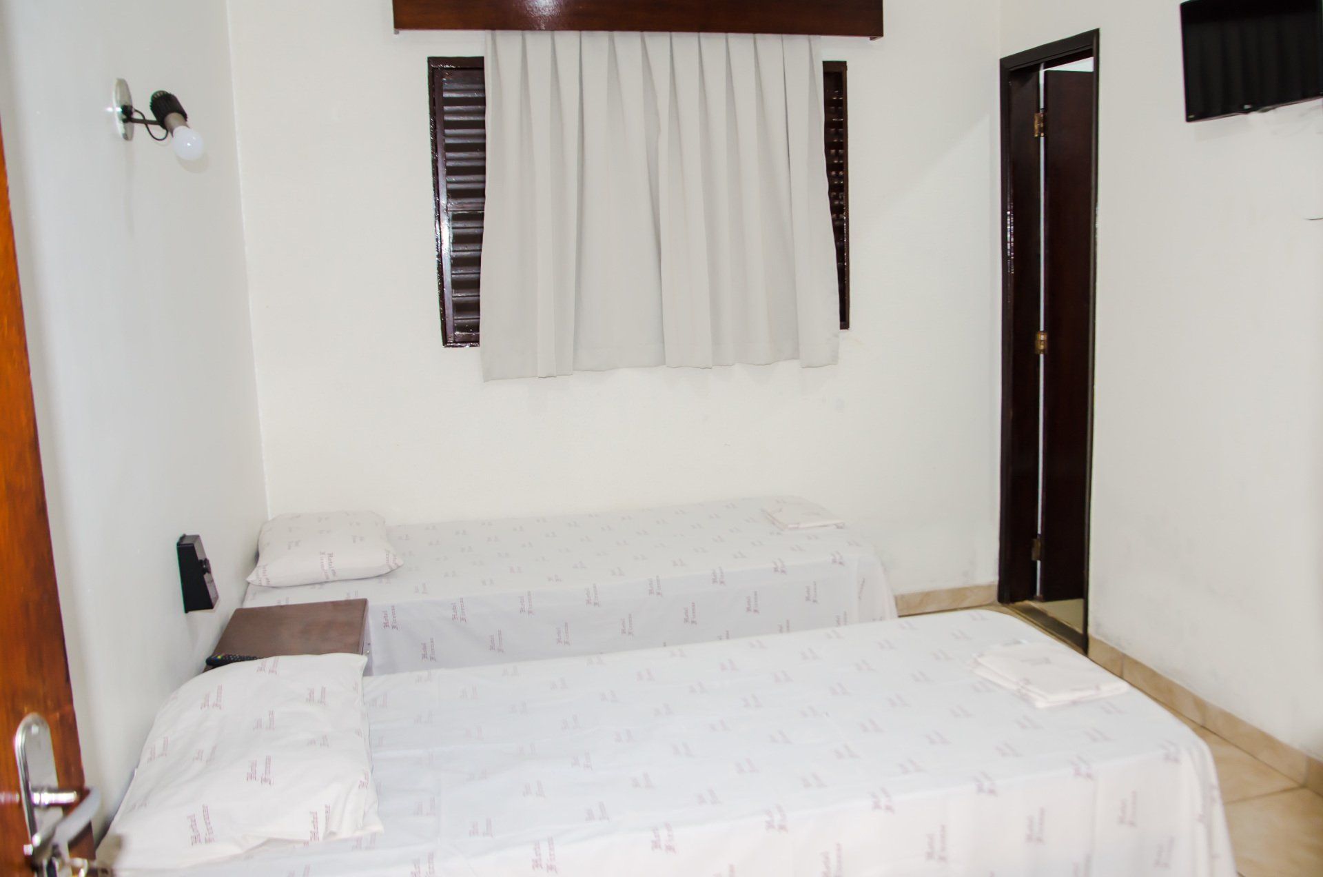 Um quarto de hotel com duas camas e uma janela