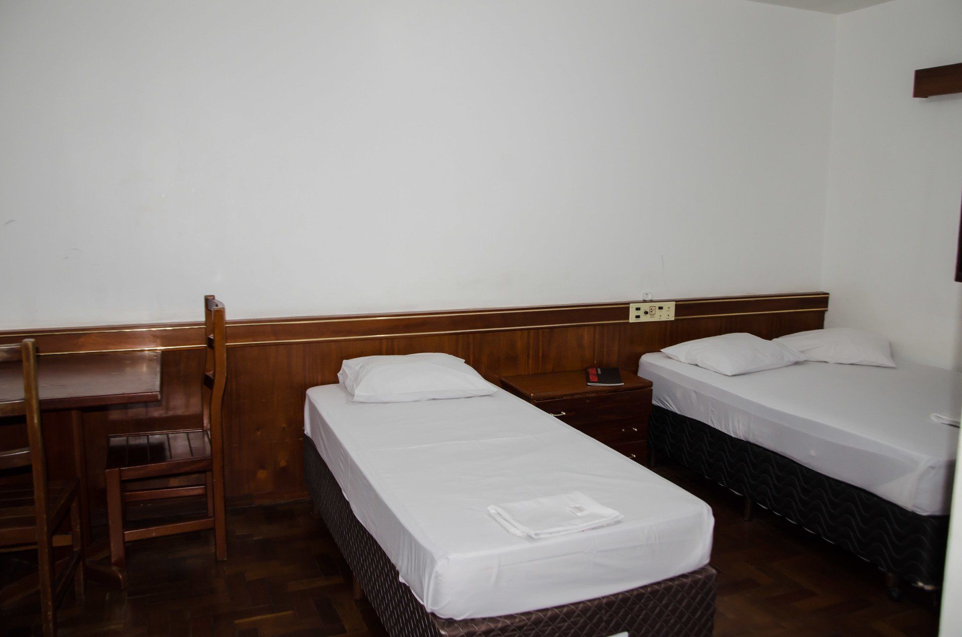 Um quarto de hotel com duas camas e uma escrivaninha