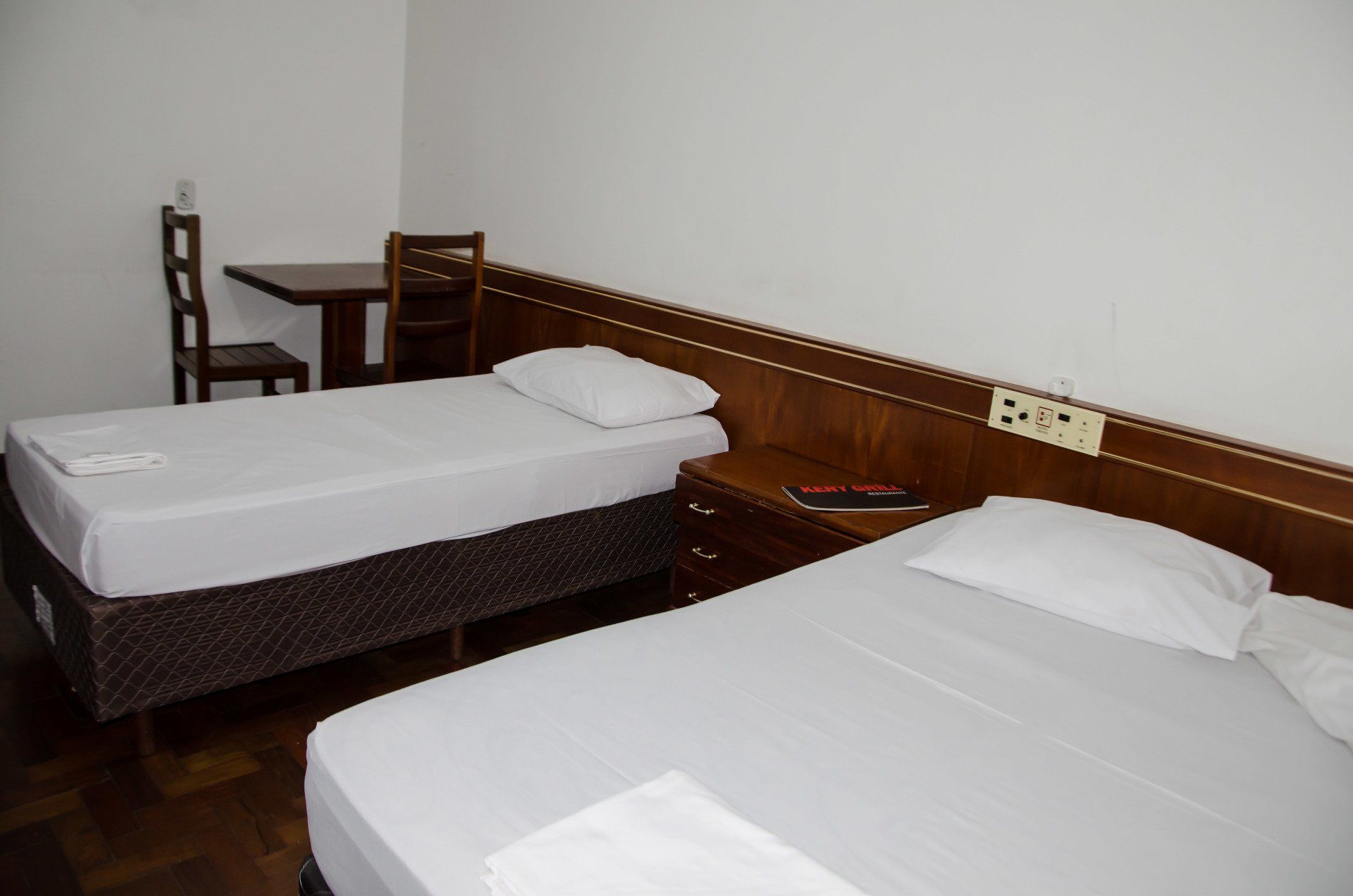 Um quarto de hotel com duas camas e uma escrivaninha