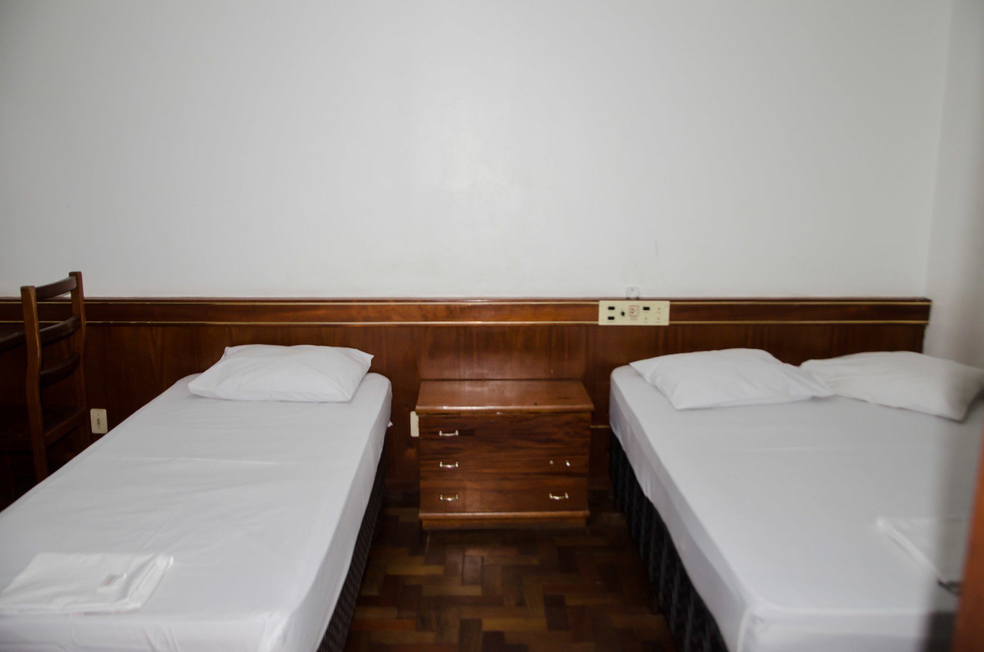 Um quarto com duas camas e uma mesa de cabeceira