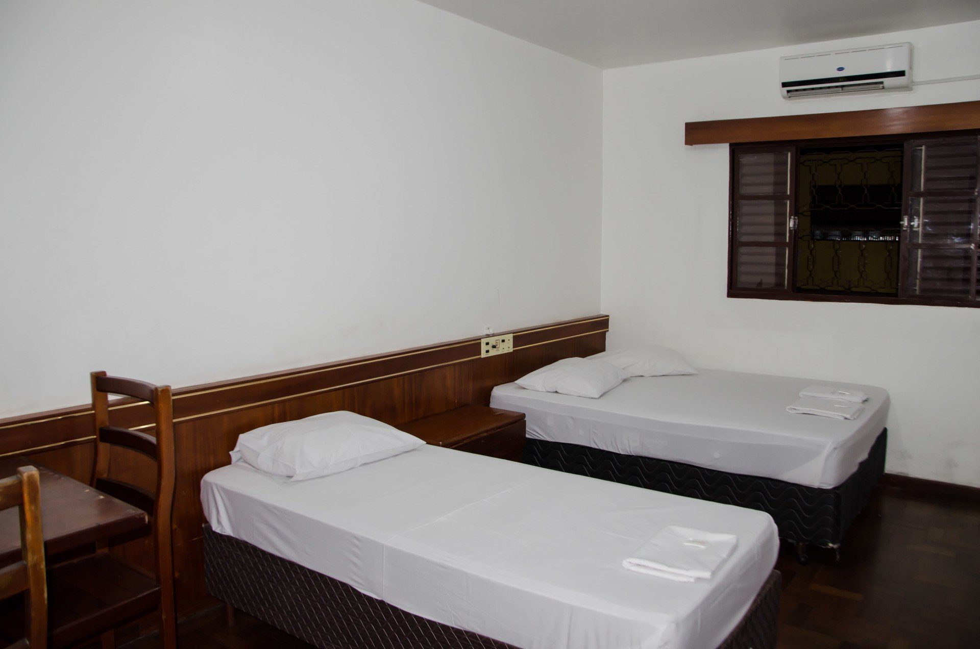 Um quarto de hotel com duas camas e uma janela