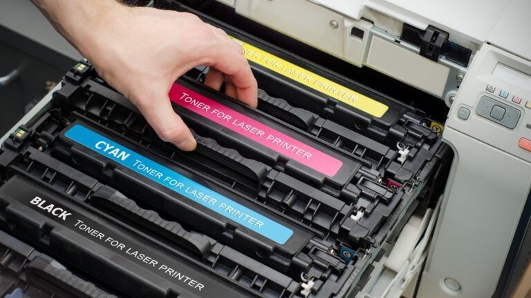 A person is taking a toner cartridge out of a printer.