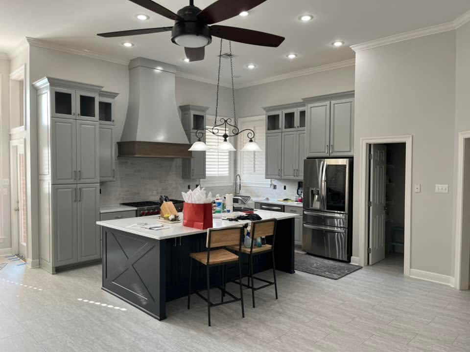 `Custom kitchen by RS Builders & Remodeling with gray cabinetry, a large island, stainless steel appliances and modern lighting`
