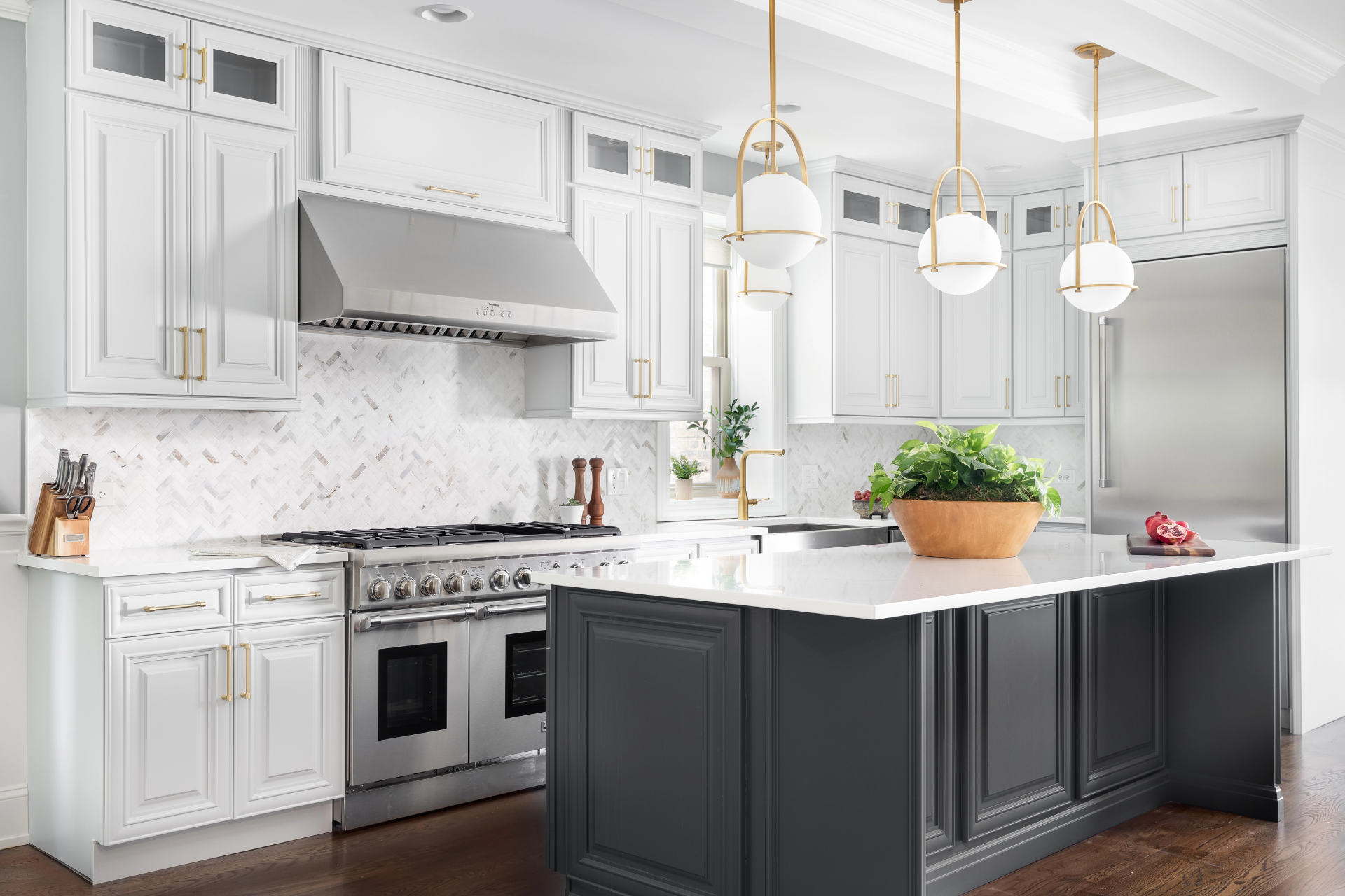 Sophisticated kitchen with white cabinets, marble backsplash, stainless steel appliances