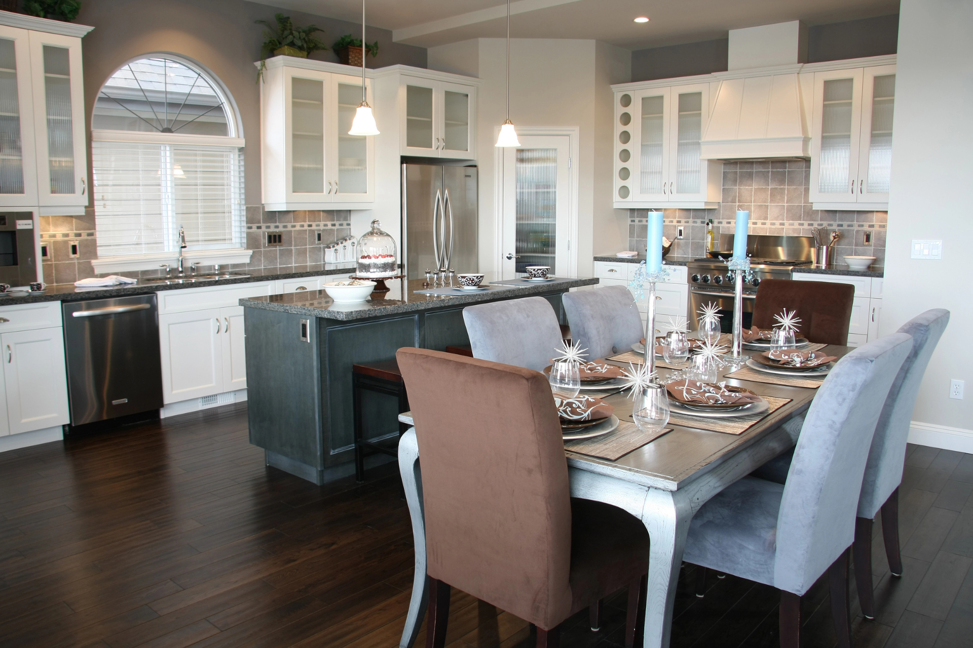 A kitchen featuring a wooden table surrounded by four chairs, with cabinets and appliances.