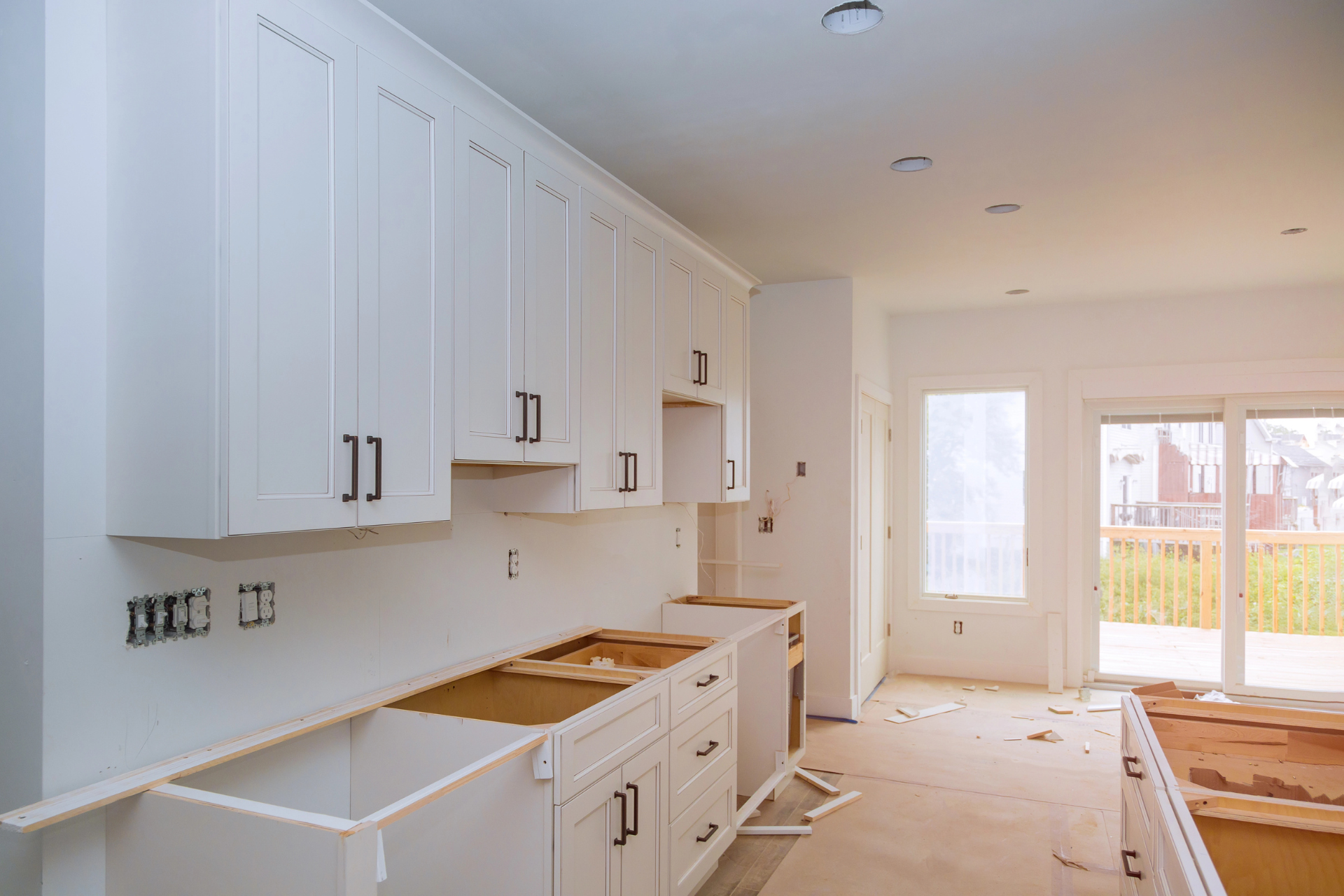 Bright Louisiana kitchen under renovation with white cabinets.