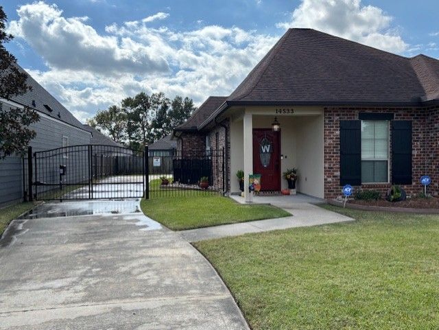 Black metal fence encloses a grassy area, trees in background.