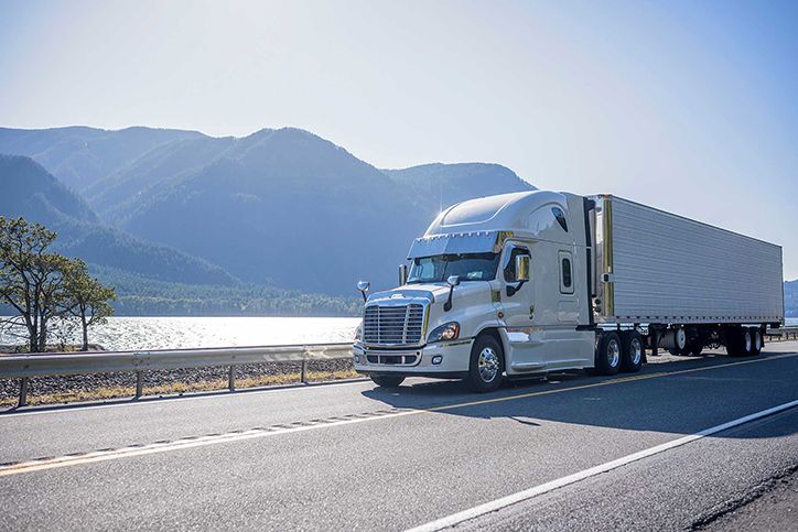 Big rig semi truck with chrome accessories transporting frozen cargo in refrigerated semi trailer