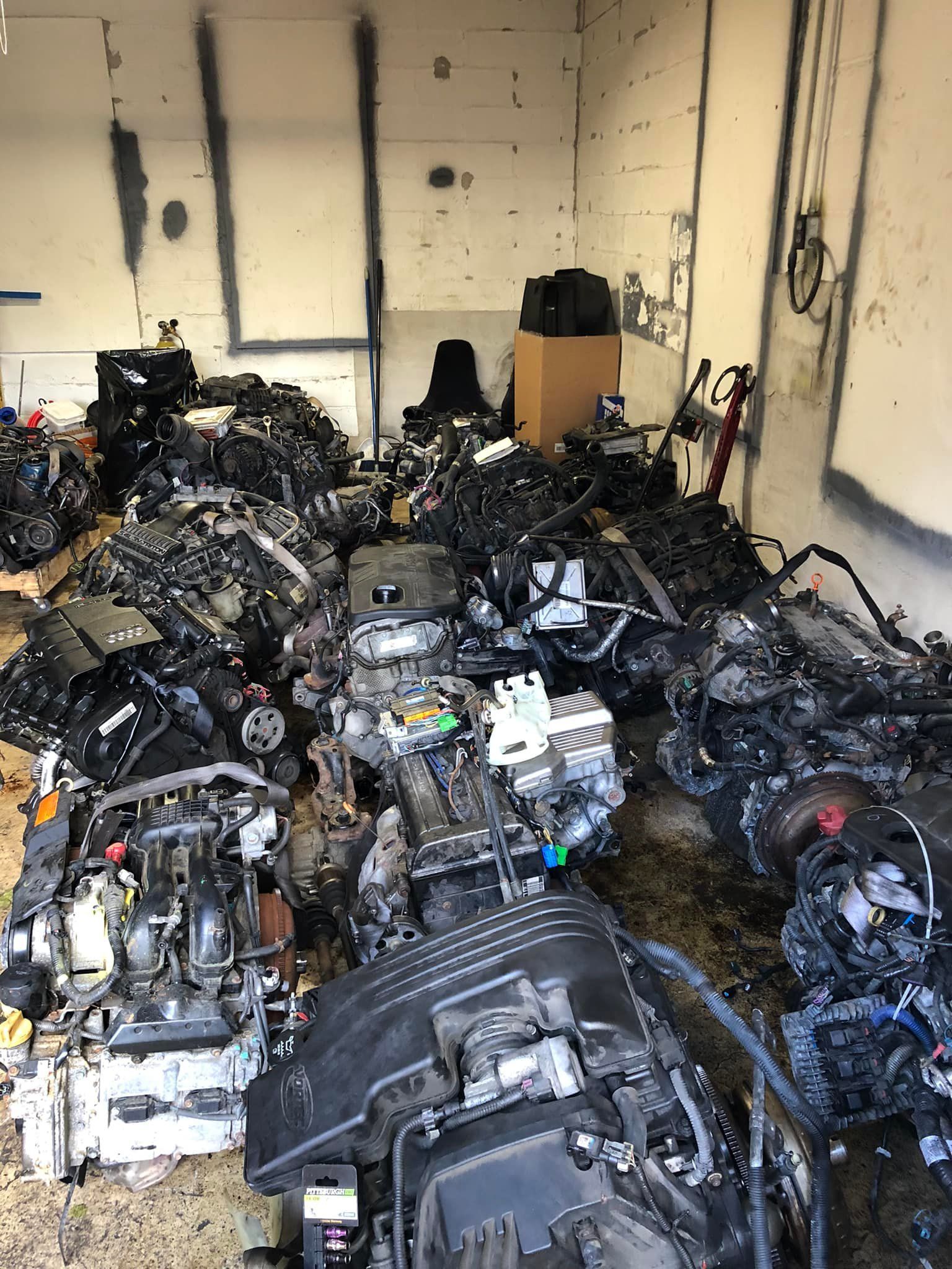 A bunch of engines are sitting in a garage.