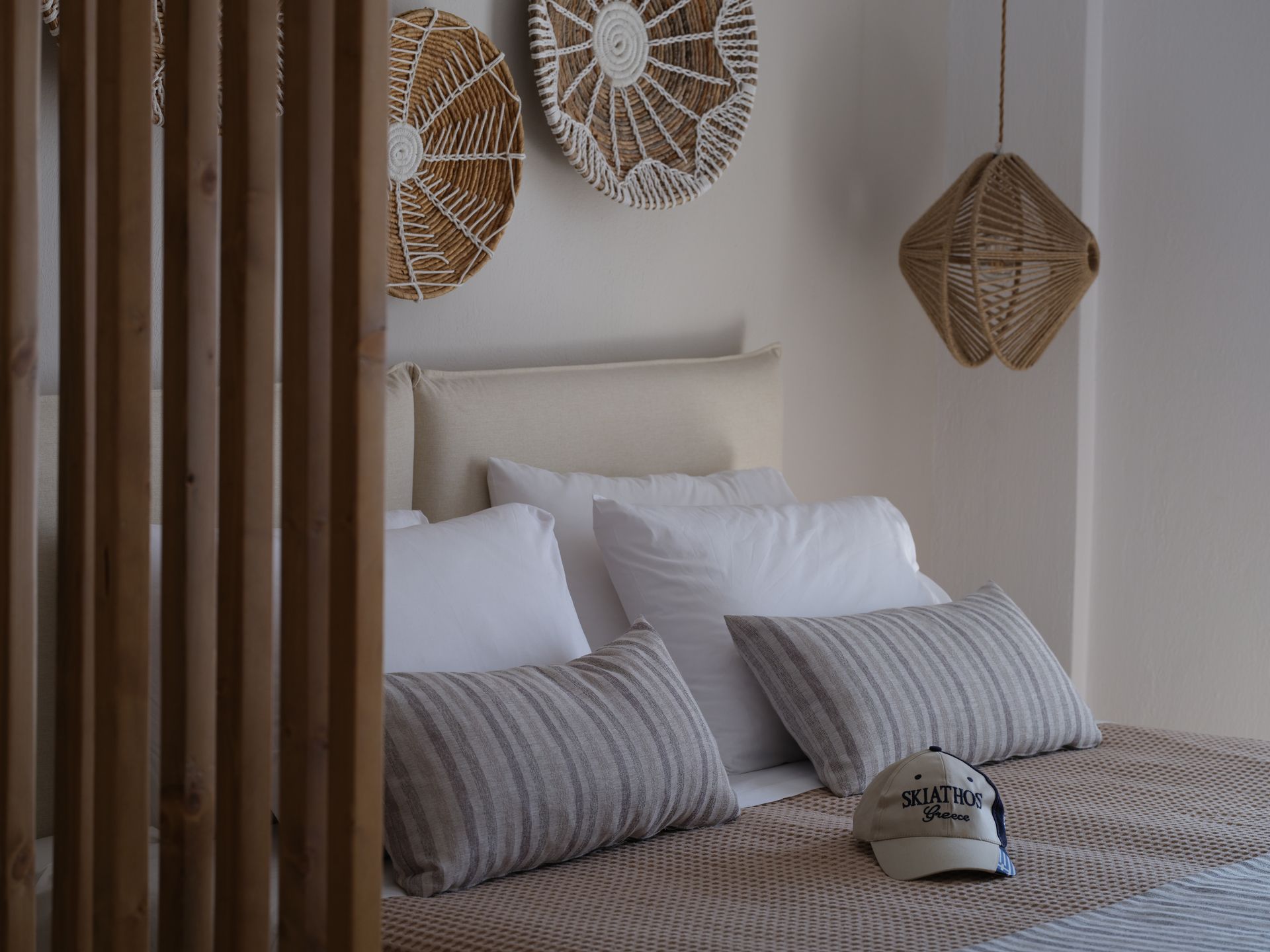 A bedroom with a bed , pillows and a hat on it.