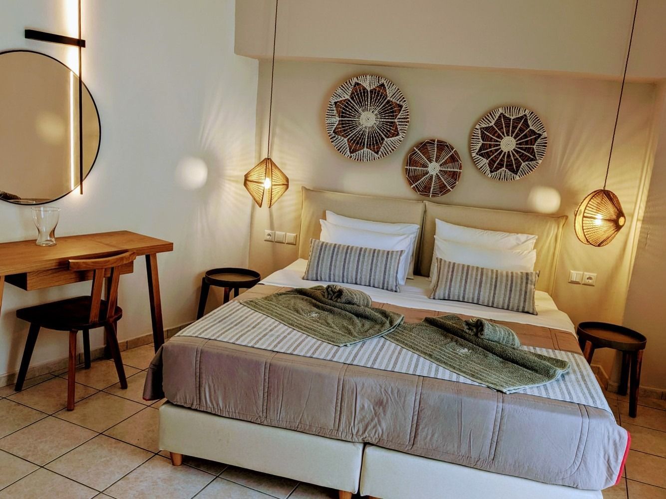 A bedroom with a bed , desk , mirror and chairs.