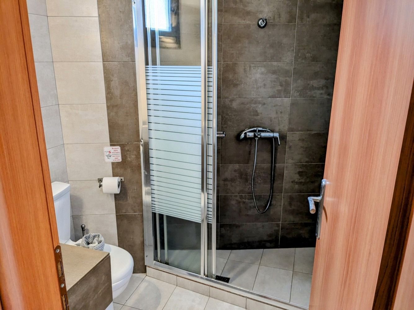 A bathroom with a walk in shower , toilet and bidet.