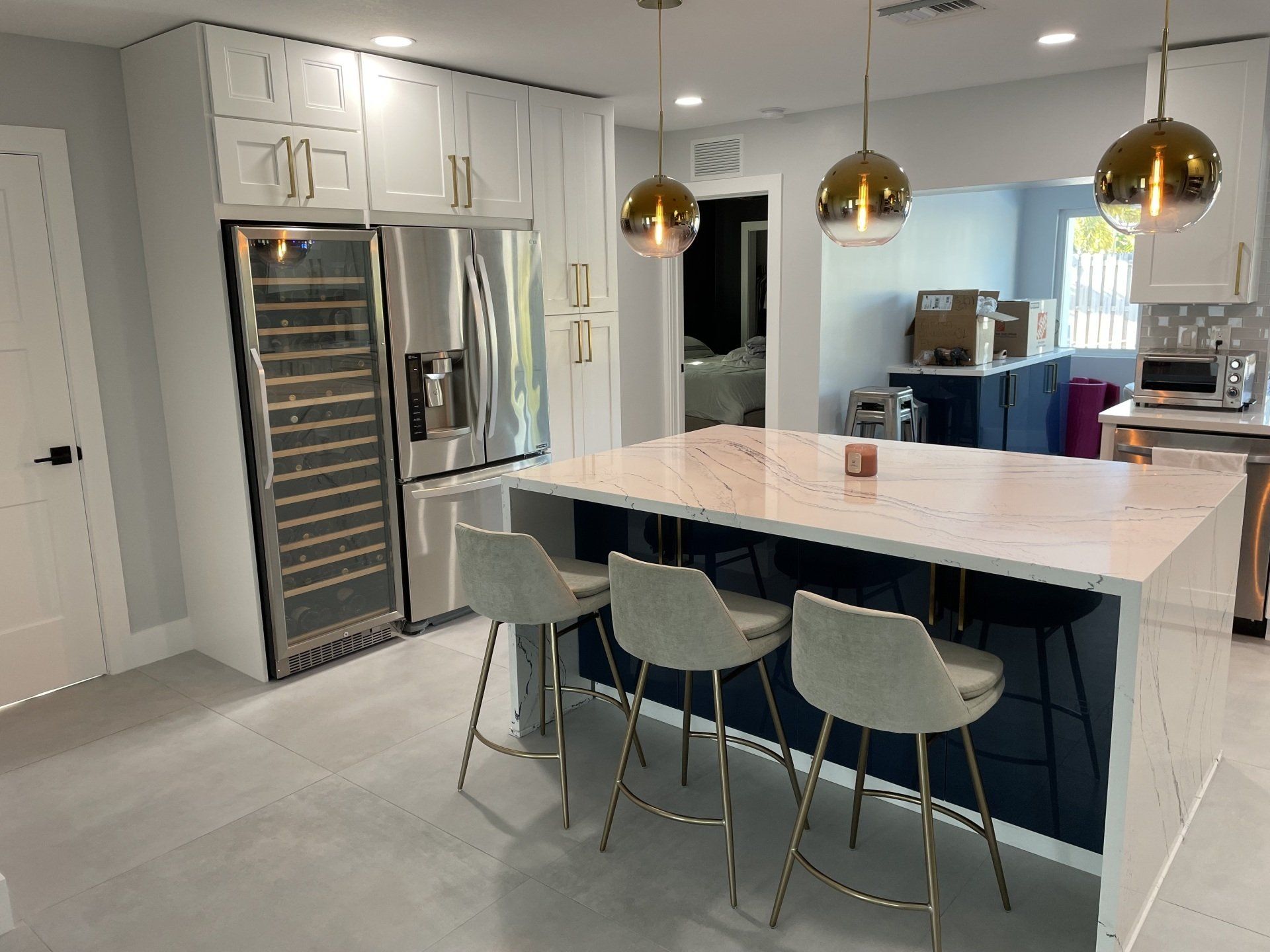 a kitchen with a large island , stools and a refrigerator .