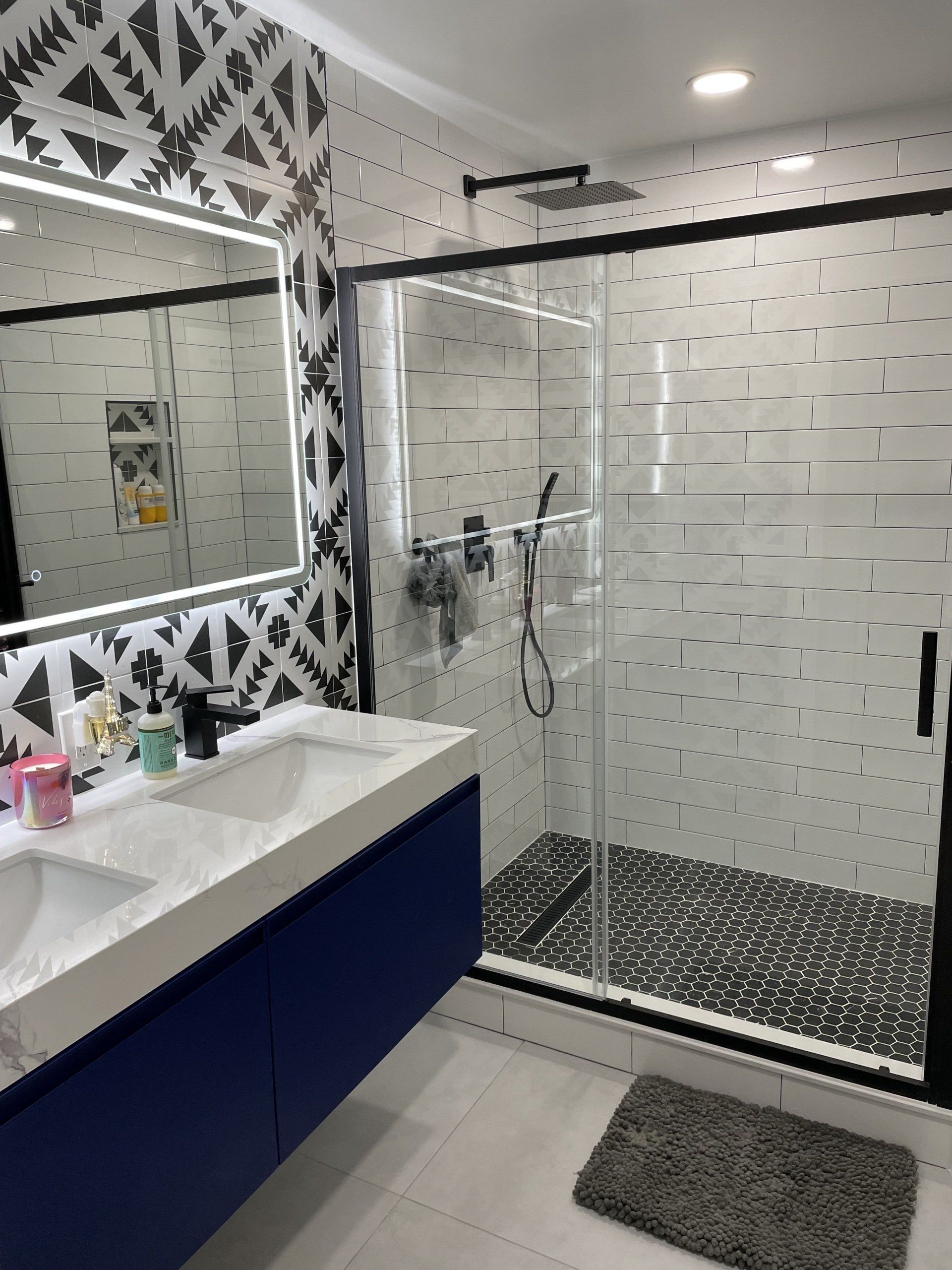 a bathroom with two sinks and a walk in shower .