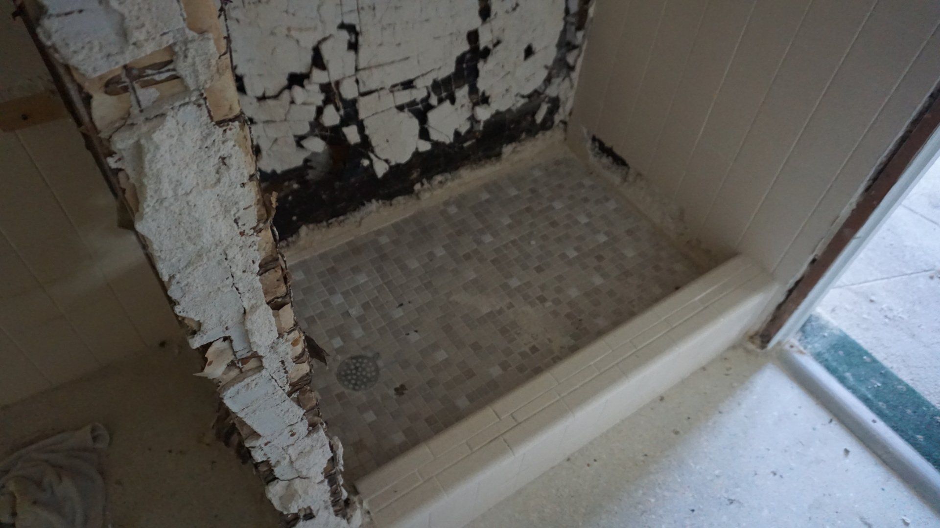 Demolishing outdated bathroom shower in old home.