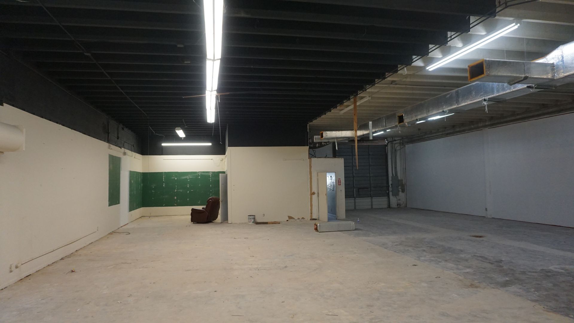 A large empty room with a chair in the middle of it.